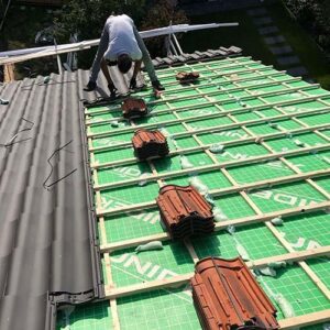 Vakbekwame dakisolatie specialisten werken aan plat dak in Almere.